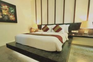 1 dormitorio con 1 cama blanca grande y 2 lámparas en VIILA JAHE, en Kuta Lombok