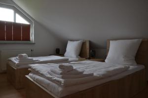 2 Betten in einem Zimmer mit Handtüchern darauf in der Unterkunft Wolf Hotel zur Linde in Künzell