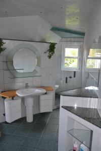 a white bathroom with a sink and a mirror at Wolf Hotel zur Linde in Künzell