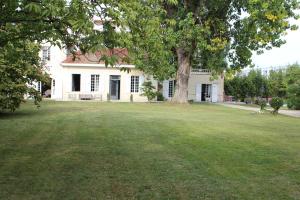 ein weißes Haus mit einem Baum im Hof in der Unterkunft Chambres d'hôtes les Marronniers in Bordeaux