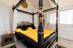 Schlafzimmer mit Himmelbett und gelber Bettwäsche in der Unterkunft Villa Santa Maria in Vrbnik + 36 Fotos