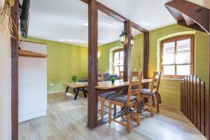 ein Esszimmer mit grünen Wänden sowie einem Tisch und Stühlen in der Unterkunft Ferienhaus Schlag Wohnung 1 in Naumburg