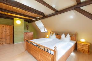 ein Schlafzimmer mit einem großen Holzbett mit weißer Bettwäsche in der Unterkunft Ferienhaus Schlag Wohnung 1 in Naumburg