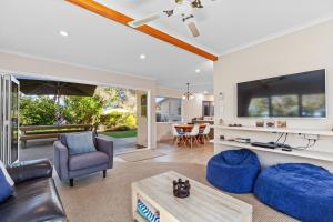 a living room with a large flat screen tv at Sandy Feet - Papamoa Beach Holiday Home in Papamoa