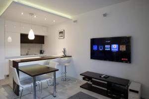 a kitchen with a table and a tv on the wall at Sopot Apartament Aquarius in Sopot