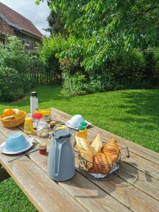 a picnic table with a basket of bread and a kettle at La Coticia en Pévèle in Coutiches