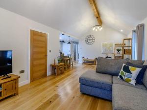 a living room with a couch and a tv at Rinstone Lodge, Thornton-Le-Dale. Moors cottage with hot tub in Thornton Dale