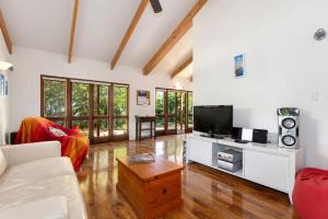 a living room with a couch and a tv at Matapouri Hideaway - Matapouri Holiday Home in Matapouri