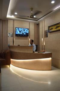 a man sitting at a reception desk in a hotel lobby at Hotel Singh Comfort Inn in Gorakhpur