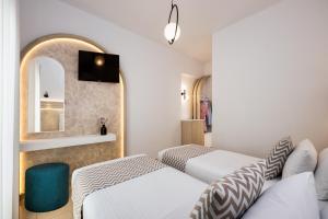 Habitación de hotel con 2 camas y espejo en Petros Villa en Fira