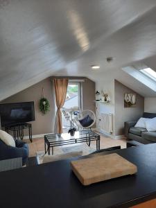 een woonkamer met een bank en een tafel bij Forest View Impeccable two bedroom house in Rostrevor