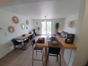 a kitchen and living room with a table and chairs at T3 Le Lou-Piscine & Parking - 5min des thermes in Gréoux-les-Bains +3 photos