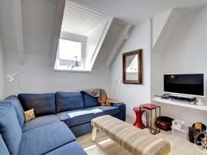 uma sala de estar com um sofá azul e uma televisão em BLANHIBLAR de Alma de Nieve em Baqueira-Beret
