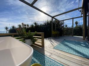 a deck with a bath tub and a view of the ocean at Ross Beach TOP10 Holiday Park in Ross