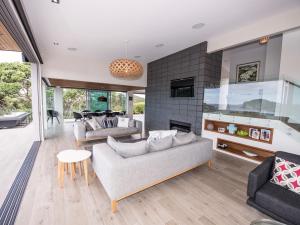 a living room with two couches and a fireplace at Moonlit Knights - Tutukaka Holiday House in Tutukaka