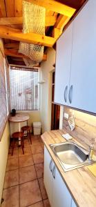 a kitchen with a sink and a table at Apartmaji Sonce Izola in Izola
