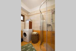 a bathroom with a shower and a washing machine at Apartmaji Sonce Izola in Izola