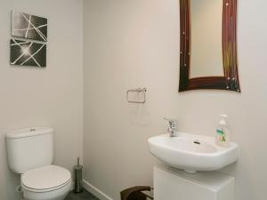 a white bathroom with a toilet and a sink at Lake Magic - Motuoapa Holiday Home in Turangi +16 photos