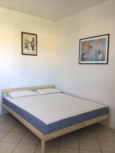 CASA EZZELINA في Romano D'Ezzelino: سرير في غرفة مع صورتين على الحائط