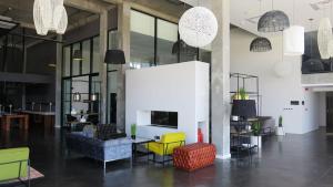 a living room with yellow and blue chairs and a fireplace at The Urban Hotel Lusaka in Lusaka