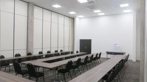 a large room with tables and chairs and a screen at The Urban Hotel Lusaka in Lusaka