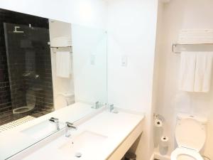 a bathroom with a sink and a toilet and a mirror at The Urban Hotel Lusaka in Lusaka