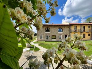 a building in the background with flowers in the foreground at Relais Montemarino in Borgomale