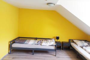 a yellow room with two beds and a yellow wall at 4 room apartment in Düren in Düren - Eifel
