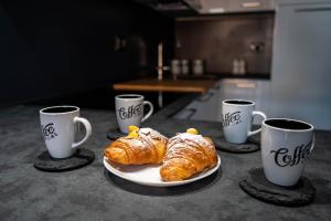 two croissants and two cups of coffee on a table at Little Venice in Sottomarina +42 photos