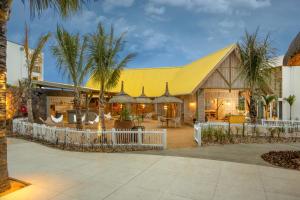 a house with a yellow roof and palm trees at Sunrise Attitude (Adults Only) in Belle Mare