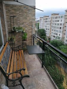 eine Bank auf einem Balkon mit einem Tisch in der Unterkunft Апартамент в най-хубавия квартал на Варна in Warna