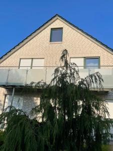 ein Haus mit einem Baum davor in der Unterkunft Apartment 28 in Stadthagen