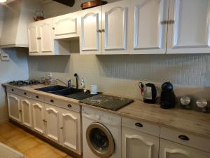 a kitchen with a sink and a washing machine at La maison d'Yvette in Le Barroux