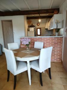 a dining room table with white chairs and flowers on it at La maison d'Yvette in Le Barroux +31 photos