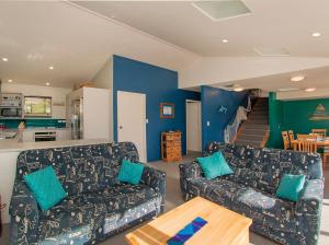 a living room with two couches and a table at Coro Beach Haven - Hahei Holiday Home in Hahei