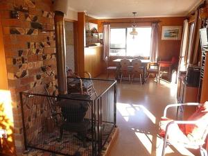 un soggiorno con gabbia per uccelli su un muro di mattoni di Cute Cottage - Cooks Beach Bach a Cooks Beach Altre 3 foto