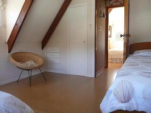 una camera da letto con un letto e una sedia di Cute Cottage - Cooks Beach Bach a Cooks Beach