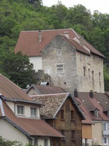 un antiguo castillo se encuentra sobre los tejados de las casas en GITE LA PETITE ECLUSE EN BORD DE LOUE, en Lods