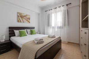 a bedroom with a bed with green pillows on it at Lindos Olive Suites in Líndos