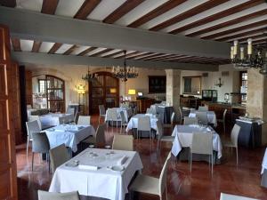 uma sala de jantar com mesas e cadeiras brancas em Parador de Zamora em Zamora