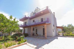 a large white house with a purple balcony at PREMIER GUEST HOUSE in Vlorë