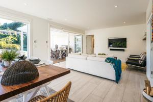 a living room with a white couch and a table at Moa Magic - Oneroa Holiday Home in Oneroa