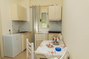 a small kitchen with a table and a white table and chairs at PREMIER GUEST HOUSE in Vlorë