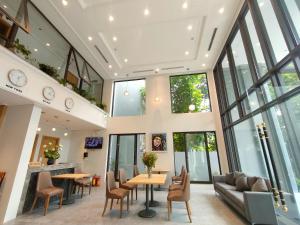 an office lobby with tables and chairs and windows at Hồng Gia Tuệ Lake View in Hanoi