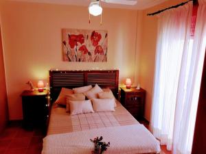 a bedroom with a large bed with white sheets and pillows at Casa con Encanto,disfruta de su paz y tranquilidad in Adzaneta