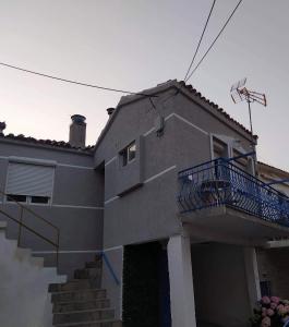 una casa con un balcón azul en el lateral de ella en Vasilis traditional House, en Samotracia