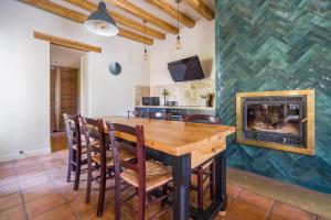 une salle à manger avec une cheminée, une table en bois et des chaises dans l'établissement LUXURY Bergerie Corsica, PARIS Orly et disney, à Varennes-Jarcy