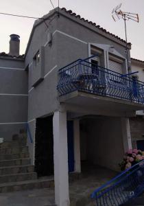 Casa con balcón azul y escaleras en Vasilis traditional House, en Samotracia