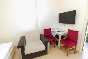 a room with a chair and a table and a television at PREMIER GUEST HOUSE in Vlorë
