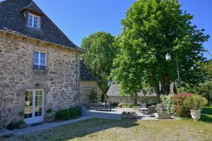 an old stone house with a tree in the yard at Domaine du Vidal in Camps